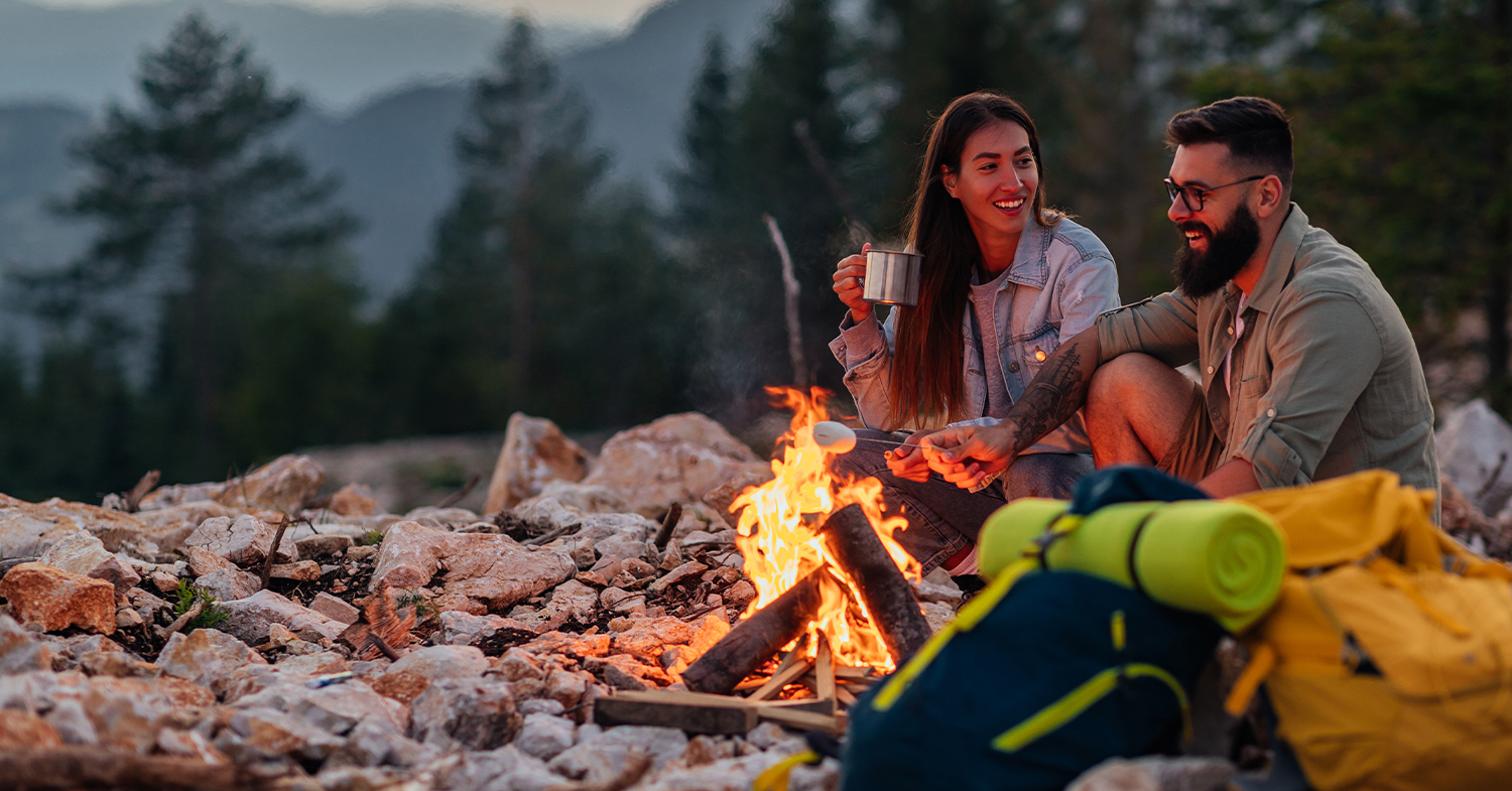 man and woman by a campfire_MAM_1500x785