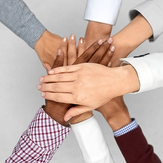 A group of people with their hands on top of each others in a go team sort of pose_Content