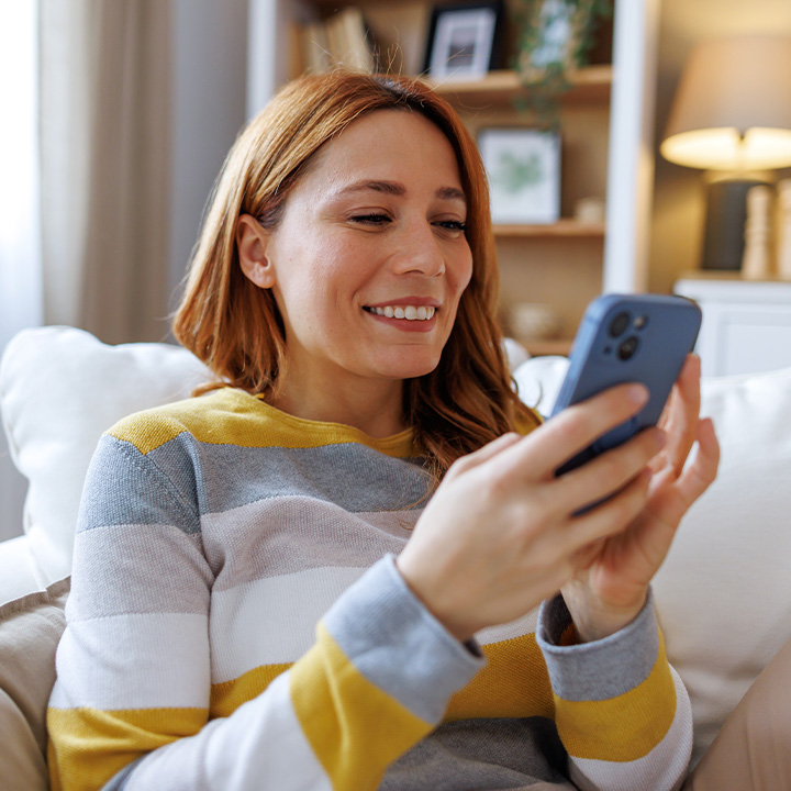 woman in a striped sweater looking at their phone_720x720