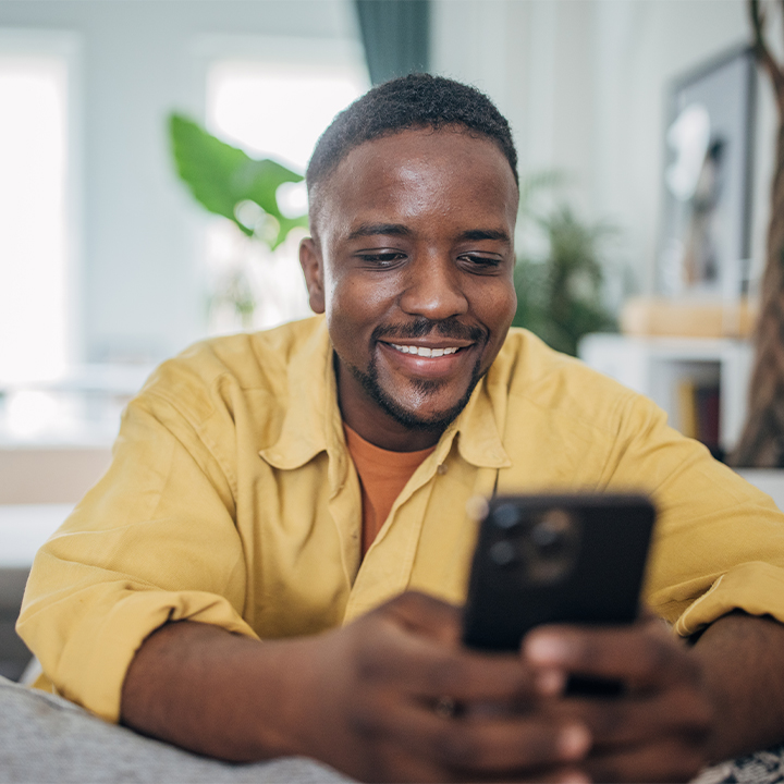 man smiling and looking at his phone