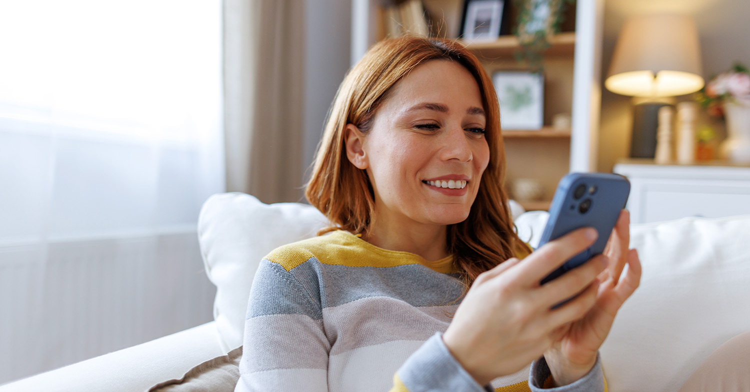 woman in a striped sweater looking at their phone_1500x785