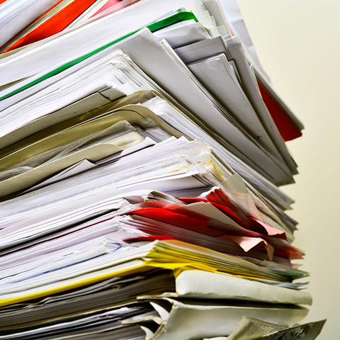 Shred and share 2021 stack of papers and folders on a desk